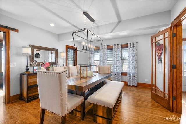 dining area featuring a notable chandelier, baseboards, and wood finished floors