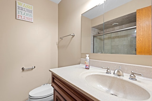 bathroom featuring vanity, an enclosed shower, and toilet