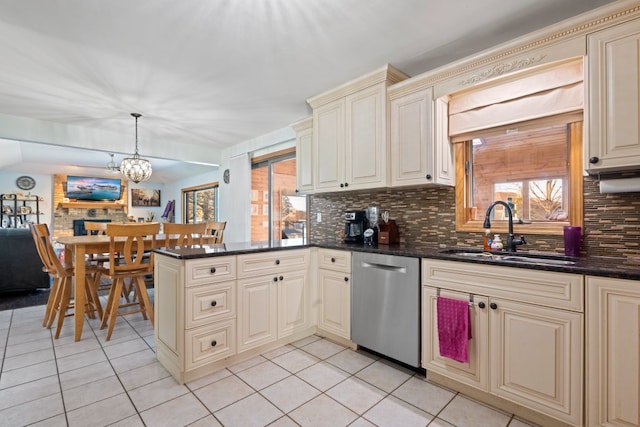 kitchen featuring dishwasher, sink, backsplash, hanging light fixtures, and cream cabinets