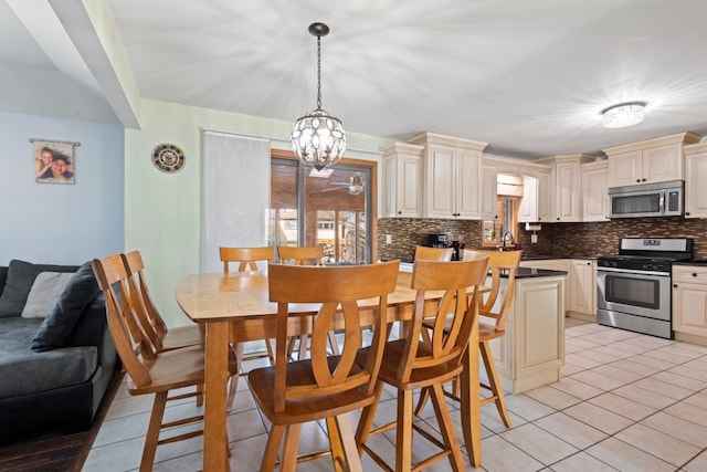 kitchen featuring appliances with stainless steel finishes, pendant lighting, decorative backsplash, and cream cabinetry