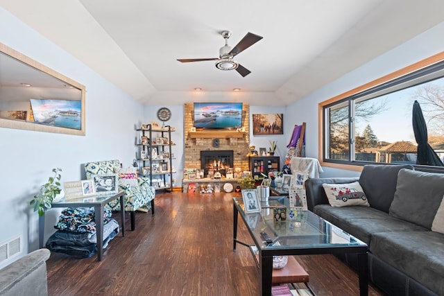 living room with ceiling fan, dark wood-type flooring, and a fireplace