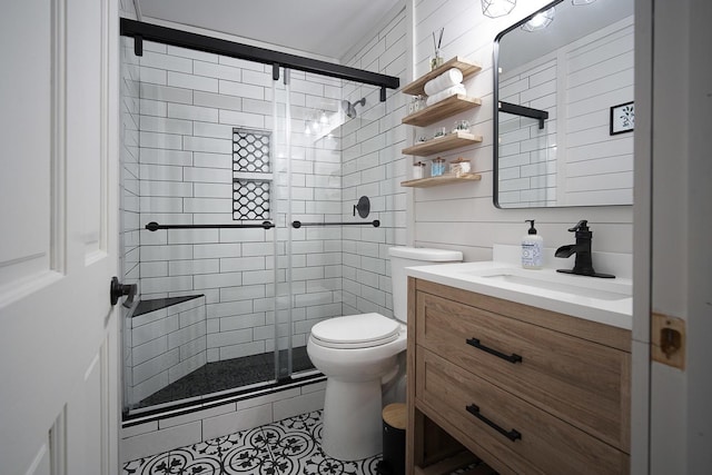 bathroom with vanity, tile patterned floors, a shower with door, and toilet