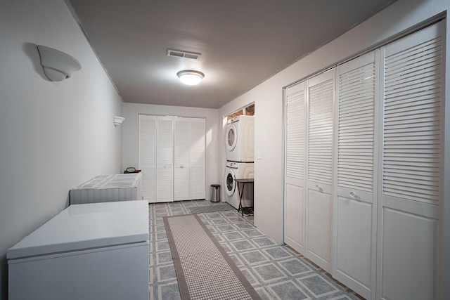 washroom featuring stacked washer / drying machine