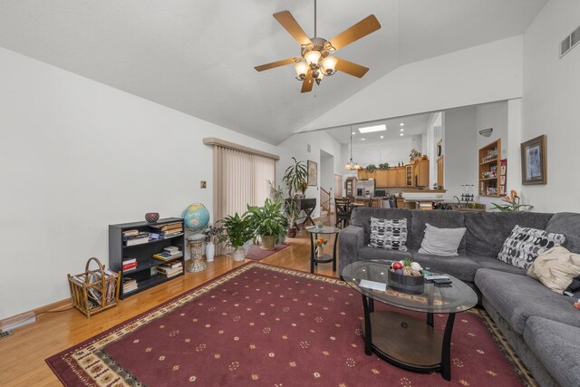 living room featuring lofted ceiling, hardwood / wood-style floors, and ceiling fan