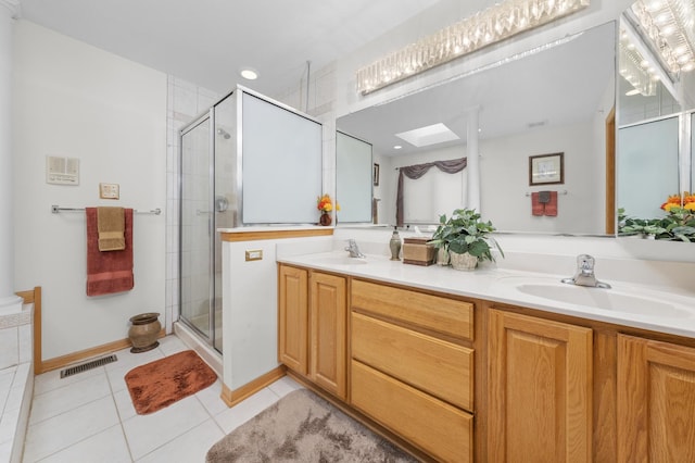 bathroom featuring a shower with door, vanity, tile patterned floors, and a skylight