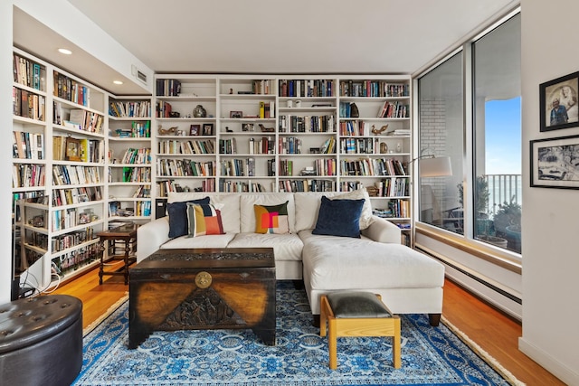 living area featuring a baseboard radiator and hardwood / wood-style floors