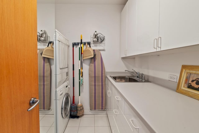 washroom featuring cabinets, stacked washer and dryer, light tile patterned flooring, and sink