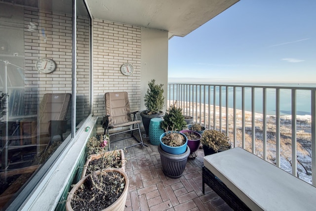 balcony featuring a water view and a view of the beach