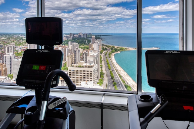 gym featuring a water view and a wall of windows