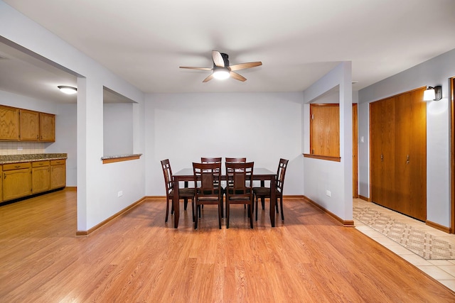 dining space with ceiling fan and light hardwood / wood-style flooring