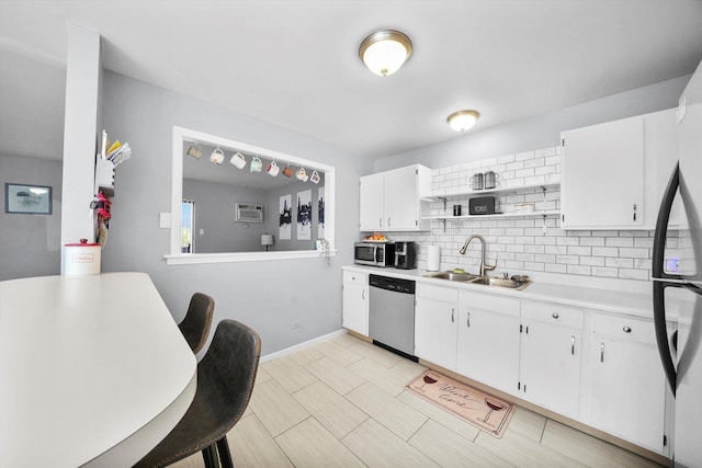 kitchen with tasteful backsplash, appliances with stainless steel finishes, sink, and white cabinets