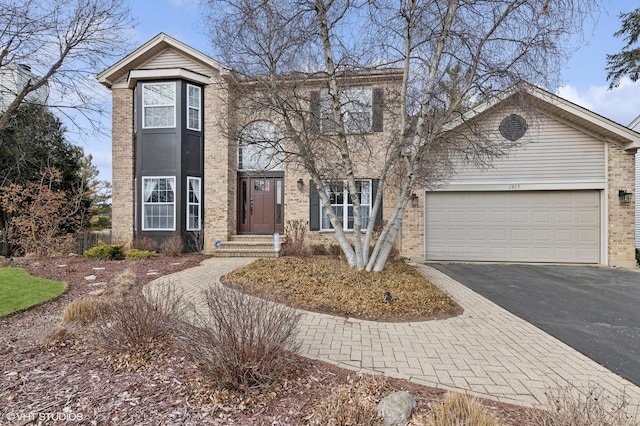 traditional home with brick siding, driveway, and an attached garage