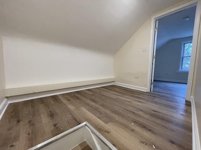 bonus room featuring dark wood-type flooring and vaulted ceiling