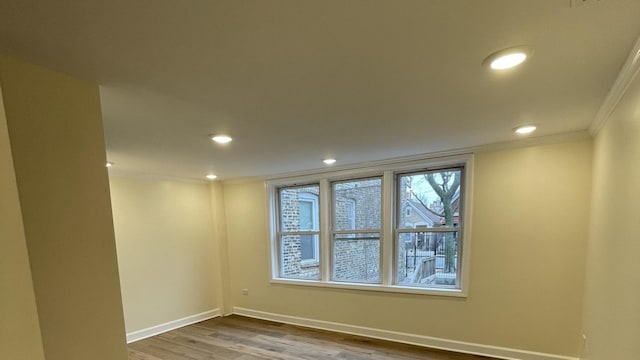 unfurnished room featuring hardwood / wood-style flooring and crown molding