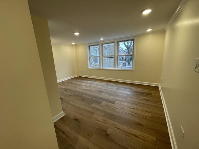 spare room featuring crown molding and wood-type flooring