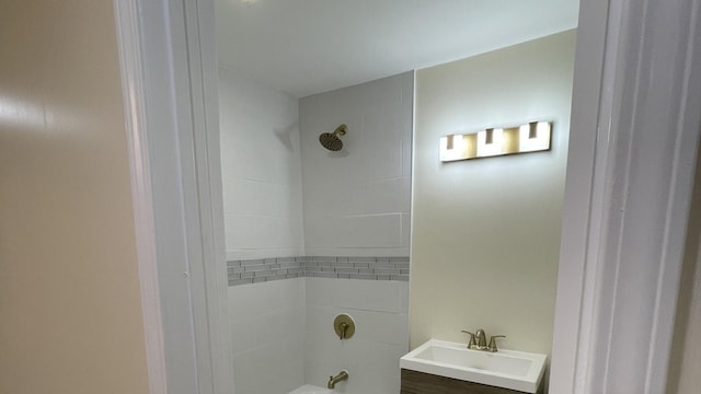 bathroom featuring tiled shower / bath combo and vanity