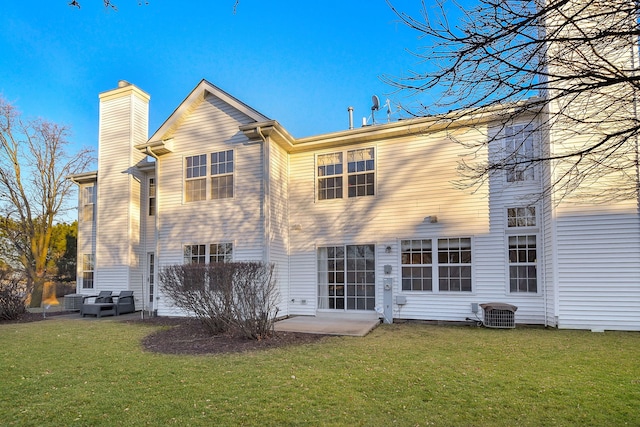 rear view of property with cooling unit, a yard, and a patio area