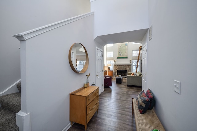 corridor featuring dark hardwood / wood-style flooring and a towering ceiling