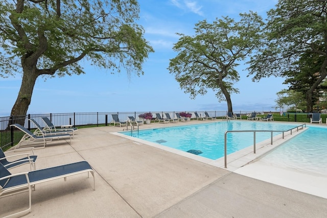 view of pool with a patio area and a water view