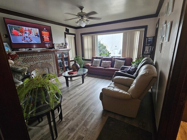 living room with ornamental molding, hardwood / wood-style floors, ceiling fan, and a fireplace