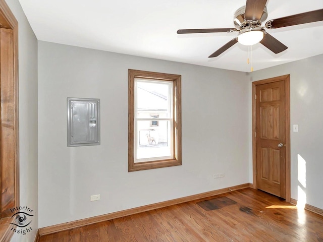 spare room featuring ceiling fan, electric panel, and light hardwood / wood-style floors