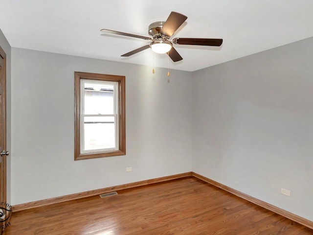 spare room featuring wood-type flooring and ceiling fan