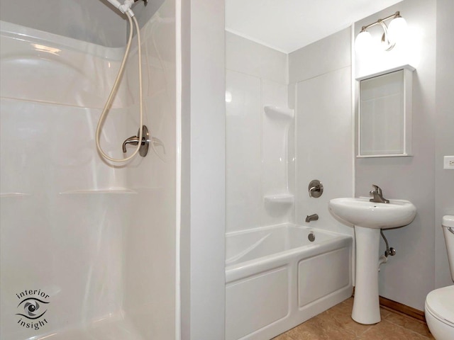 bathroom with tile patterned floors, shower / washtub combination, and toilet