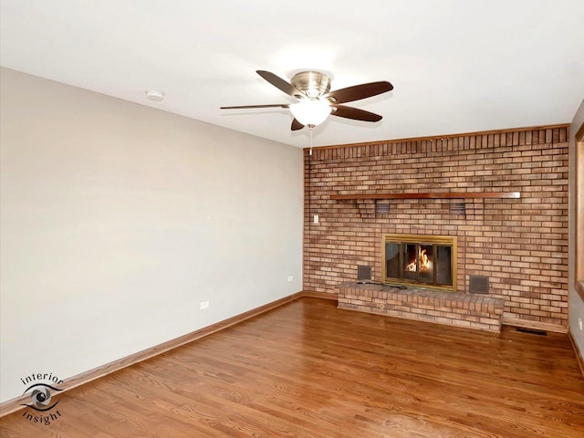 unfurnished living room featuring a brick fireplace, hardwood / wood-style flooring, and ceiling fan