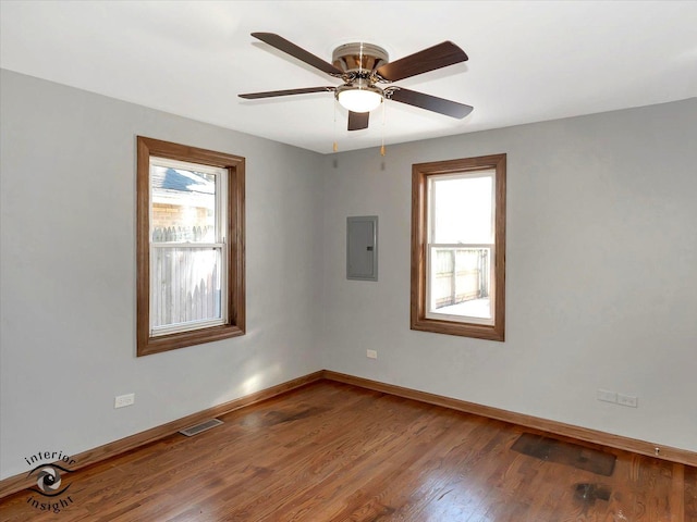 unfurnished room featuring wood-type flooring, electric panel, and ceiling fan