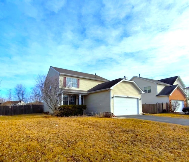 view of property featuring a garage and a front lawn