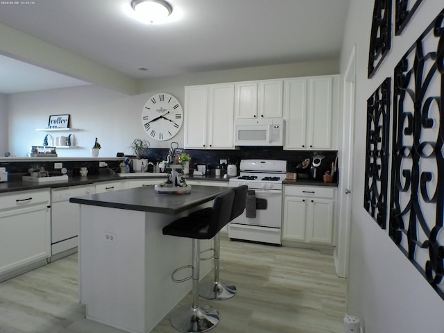 kitchen featuring white cabinetry, light wood-type flooring, white appliances, and decorative backsplash