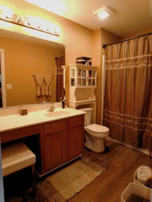 bathroom featuring vanity, hardwood / wood-style floors, a shower with curtain, and toilet