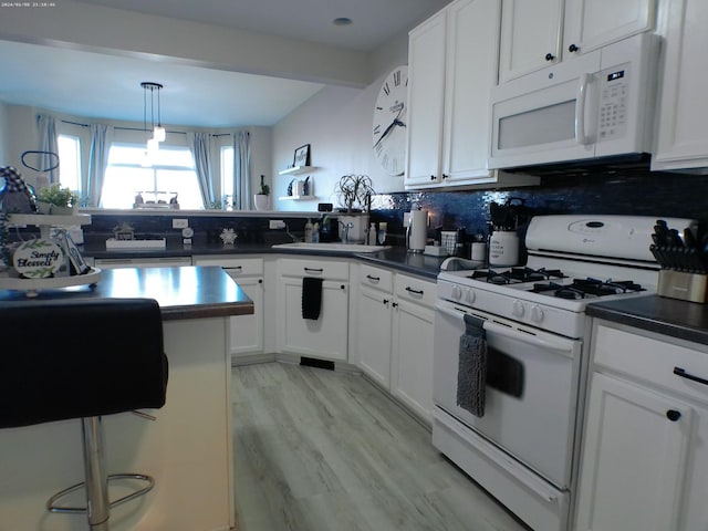 kitchen featuring decorative light fixtures, sink, white cabinets, decorative backsplash, and white appliances