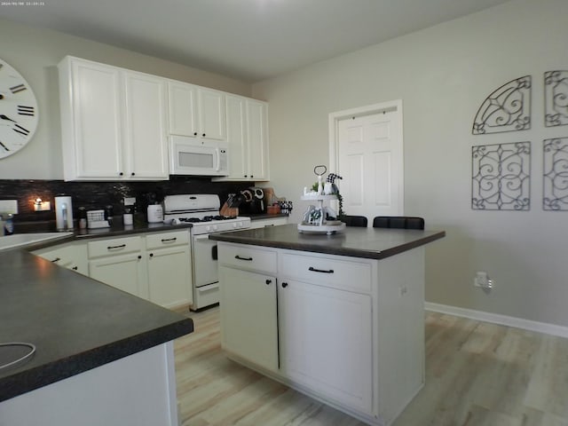 kitchen featuring white cabinetry, white appliances, and a center island