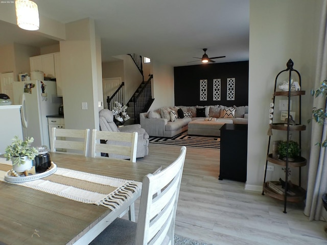 dining space with light hardwood / wood-style flooring and ceiling fan