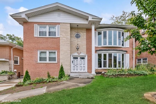 view of front of property with a front lawn and brick siding