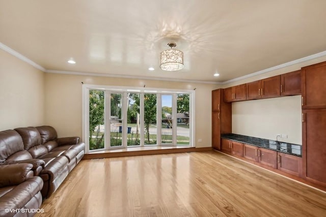 unfurnished living room with crown molding and light hardwood / wood-style floors