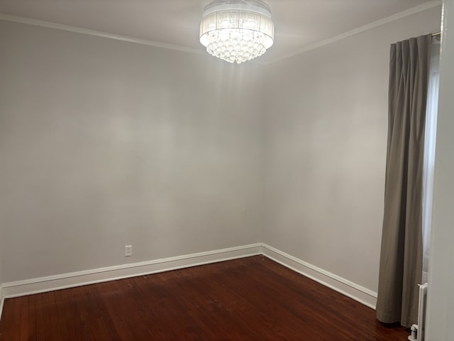 empty room with dark hardwood / wood-style flooring, ornamental molding, and an inviting chandelier