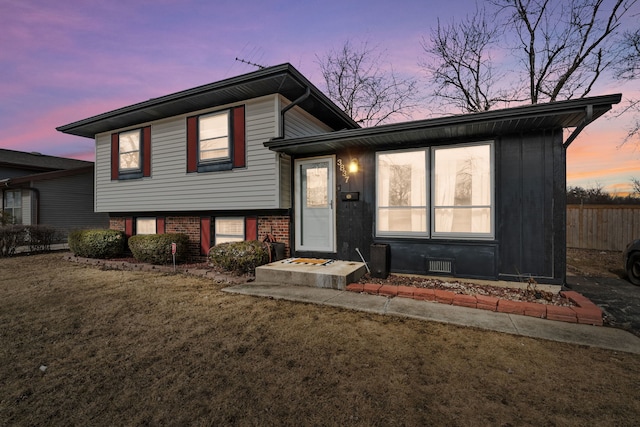 split level home with a lawn