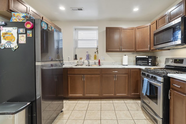 kitchen with sink, stainless steel appliances, and light tile patterned flooring