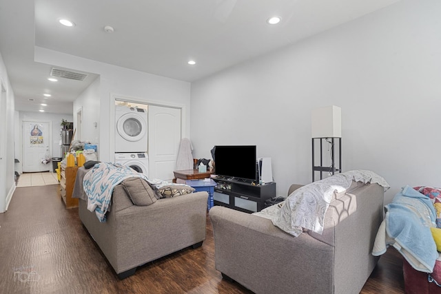 living room with dark wood-type flooring and stacked washing maching and dryer