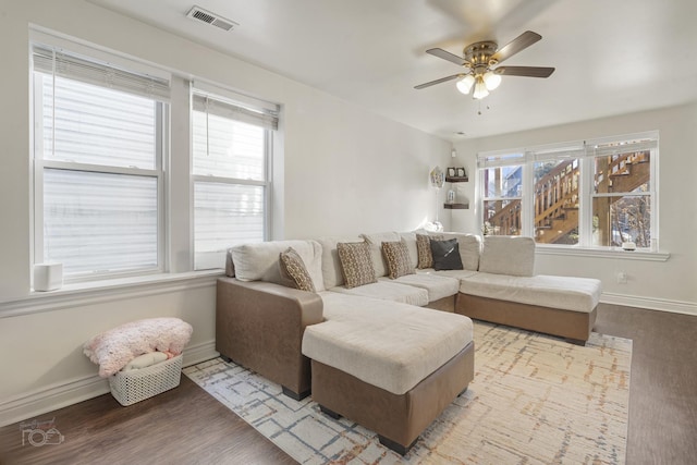 living room featuring plenty of natural light, ceiling fan, and light wood-type flooring