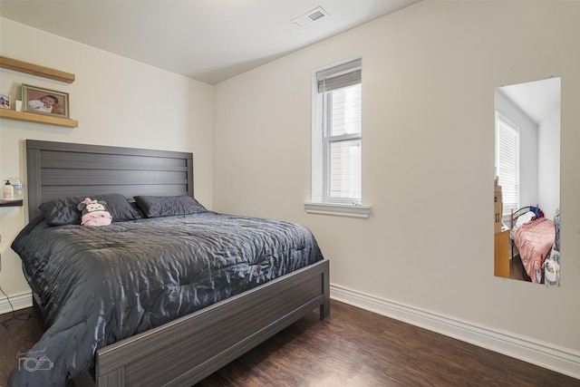 bedroom with dark hardwood / wood-style flooring