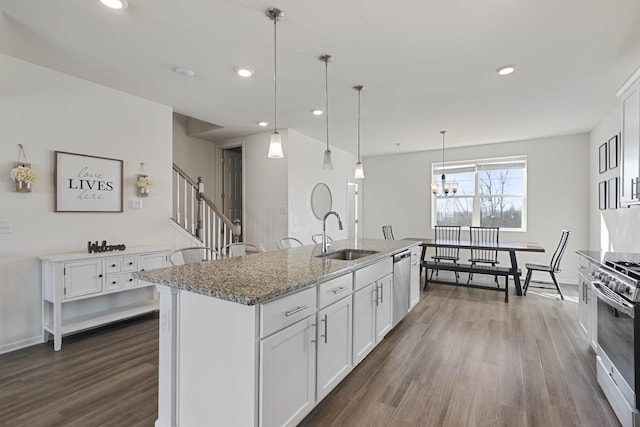 kitchen with white cabinetry, a kitchen island with sink, and sink