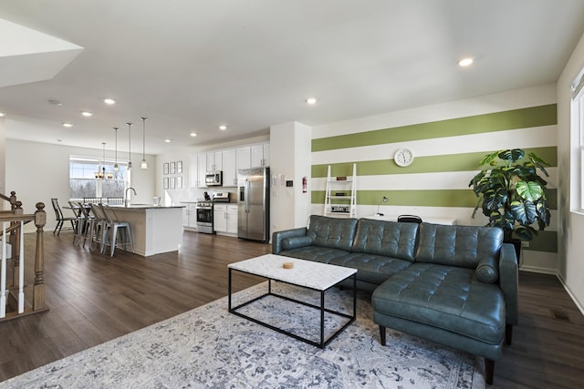 living room featuring sink and dark hardwood / wood-style floors