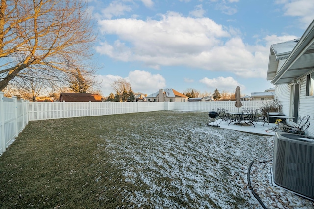 yard layered in snow featuring central AC unit and a patio