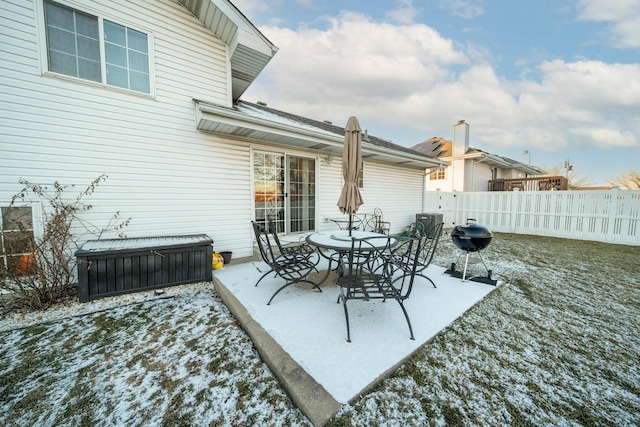 snow covered patio with a grill