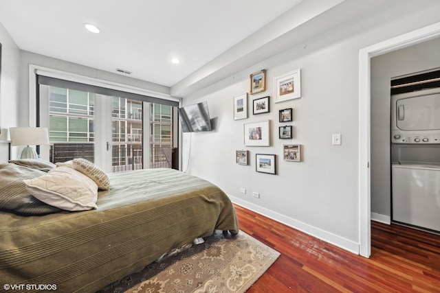 bedroom featuring stacked washer / drying machine and dark hardwood / wood-style floors