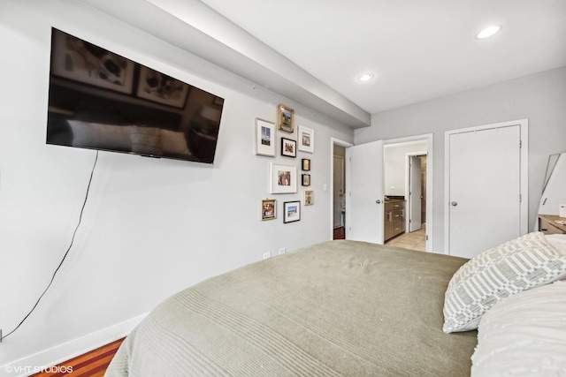 bedroom with ensuite bath and light hardwood / wood-style flooring