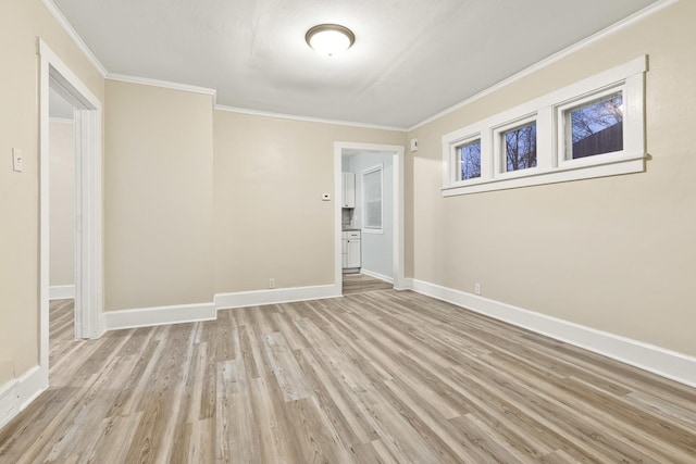 unfurnished room with ornamental molding and light wood-type flooring